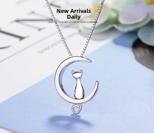 Macro shot of silver crescent moon and cat pendant necklace with elegant box chain