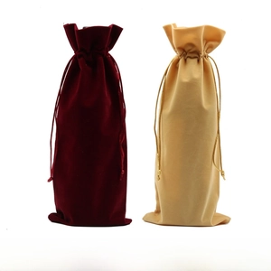Detail view of premium velvet wine bags in burgundy and champagne gold with gold drawstrings