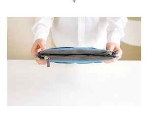 Detailed top view of a blue multi-layered nylon storage bag with three zippers