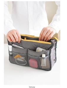 Detail view of a slate gray handbag organizer with yellow zipper and mesh pockets