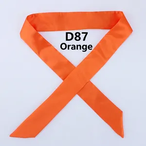 Detail view of smooth orange satin narrow scarf with glossy finish and elegant texture