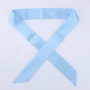 Detailed view of the sky blue satin skinny scarf tied around a handbag handle