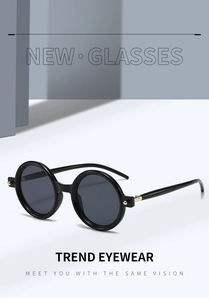 Detail view of retro round sunglasses with black glossy frames and gold rivet accents