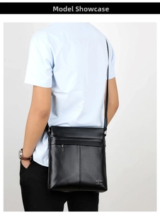 Rear view of a man wearing a black leather messenger bag with an adjustable strap