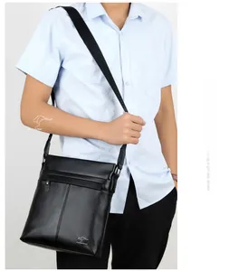 Close-up of black crossbody bag featuring metallic kangaroo logo and embossed strap details