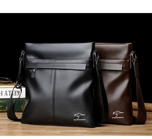 Business style black and brown leather crossbody bags with adjustable straps on a wood table