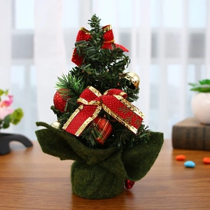 Detailed view of 20cm mini Christmas tree with red bows, gold bells and gift box ornaments