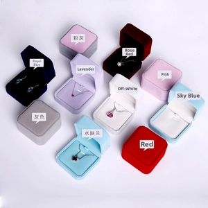 Variety of velvet jewelry boxes in multiple colors displaying necklaces and earrings