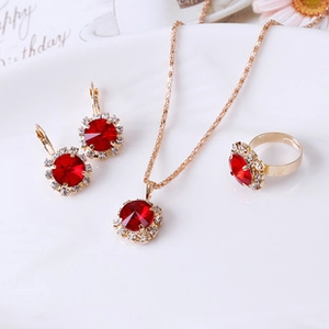 Luxurious red crystal jewelry set with necklace, earrings, and ring on a white plate