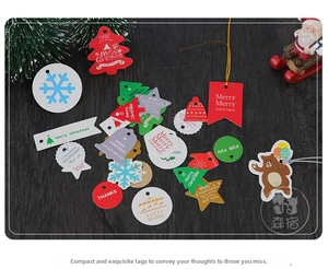 Flat lay of colorful Christmas paper gift tags with festive patterns on wood background