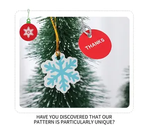 Close-up of snowflake and red Thanks gift tags hanging on green Christmas tree branches