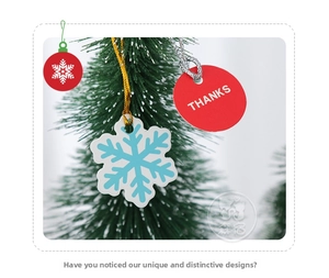 Close-up of snowflake and red Thanks gift tags hanging on green Christmas tree branches