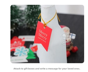 Close-up of a festive red Christmas paper tag with golden string on a bottle neck