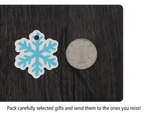 Blue and white snowflake gift tags shown next to a coin for size scale on wood background