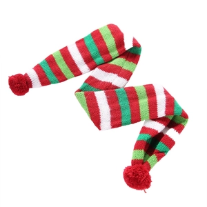 Christmas dog scarf with red and green knit stripes and pom poms on white background