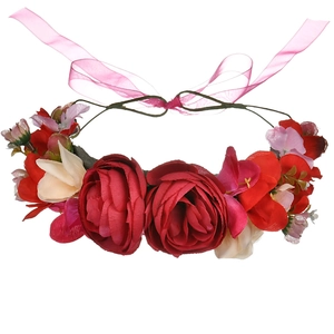 Detailed view of red velvet rose hair clip with pink ribbons and floral accents