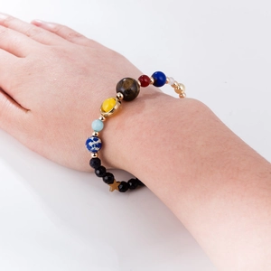 Detailed shot of solar system planet bracelet with natural stones and gold star charm