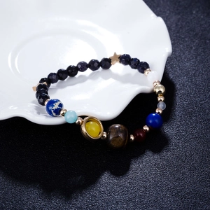 Macro detail of solar system planet bracelet with natural stone beads and star charm