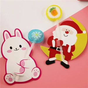 Detail of cartoon bunny and Santa lollipop paper card holders on pink background