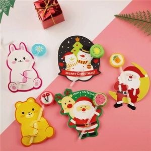 Flat lay of colorful Christmas lollipop paper cards with Santa and animal designs