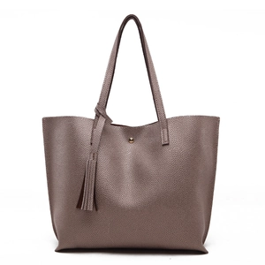 Close-up of litchi texture PU leather tote with tassel and magnetic buckle closure