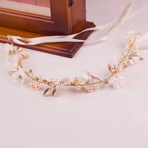 Detail of bridal headband with gold wire, white flowers, pearls and crystal rhinestones