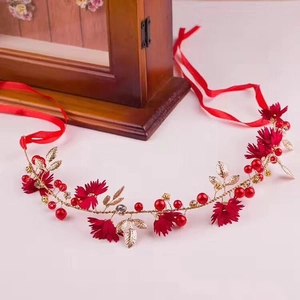 Detail of red floral bridal headband with crystals, berries and gold metal leaves