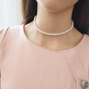 Close-up of minimalist 925 sterling silver pearl choker on neck with elegant luster