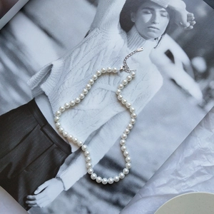 Detail of 925 silver shell pearl necklace on a fashion magazine background