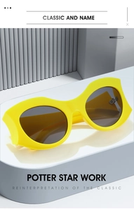 Dettaglio di occhiali da sole ovali gialli alla moda con lenti scure su piedistallo