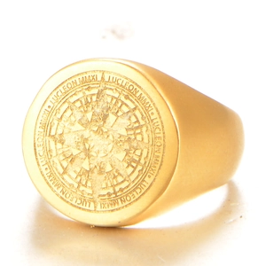 Close-up of golden compass signet ring with matte finish and engraved brand details