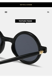 Close-up of retro black round frame sunglasses with polished finish and gold metal hinges