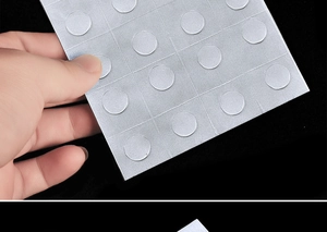 Close-up detail view of double sided adhesive balloon glue dots sheet arranged in a grid pattern.