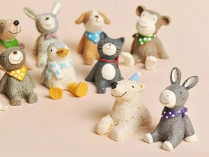 Close-up of 9 miniature resin animals like bears and penguins with colorful scarves