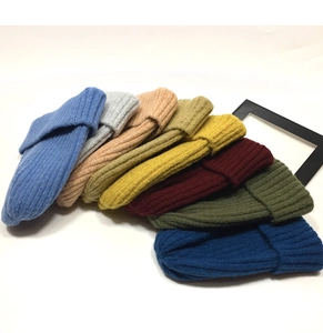 Flat lay of colorful knit beanies showing a variety of winter colors and texture