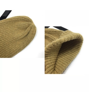 Close-up of the khaki knit beanie showing top stitching and ribbed hem texture
