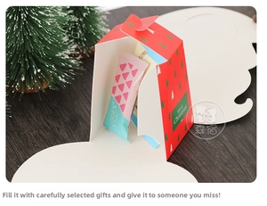 Close-up of a festive red Christmas gift box with tree patterns and gold lettering