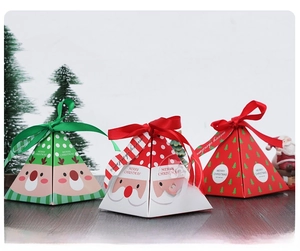 Three assorted pyramid-shaped Christmas gift boxes with ribbons on dark wooden background