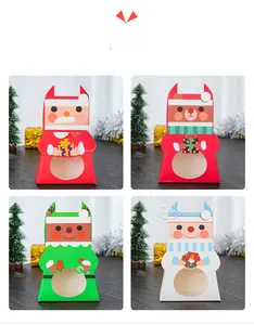 Close-up of four Christmas treat boxes with Santa, reindeer, and snowman window designs
