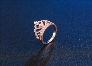 Macro shot of rose gold crown ring with pavé micro-set diamonds on dark blue glitter background