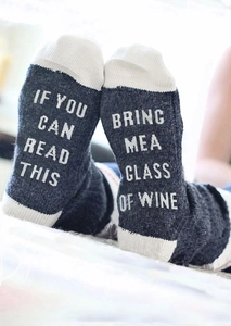 Close-up of funny If You Can Read This Bring Me A Glass Of Wine lettering on grey cotton socks