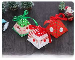 Close-up of pyramid Christmas candy gift boxes with festive ribbons and reindeer prints