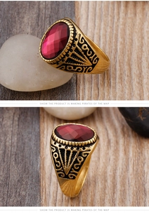 Detail of vintage men's ring with red faceted gemstone and golden engraved patterns
