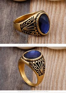 Macro detail of men's vintage gold ring with oval blue gemstone and floral engravings