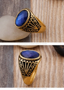 Macro shot of men's vintage gold ring with large blue oval gemstone and black carvings
