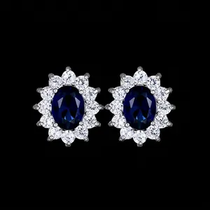 Elegant halo stud earrings with oval dark blue sapphire-style stone and white zircons