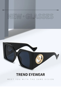 Close-up of square black sunglasses featuring gold circular metal logo on the temple