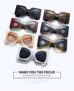 Flat lay of oversized square sunglasses in seven assorted colors and gradients
