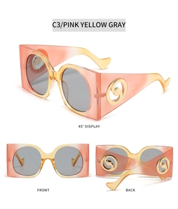 Detail view of pink, yellow, and gray gradient frame sunglasses with golden metal logo