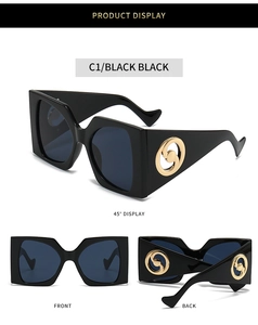 Macro detail of square sunglasses featuring bold black frames and gold vortex temple accents